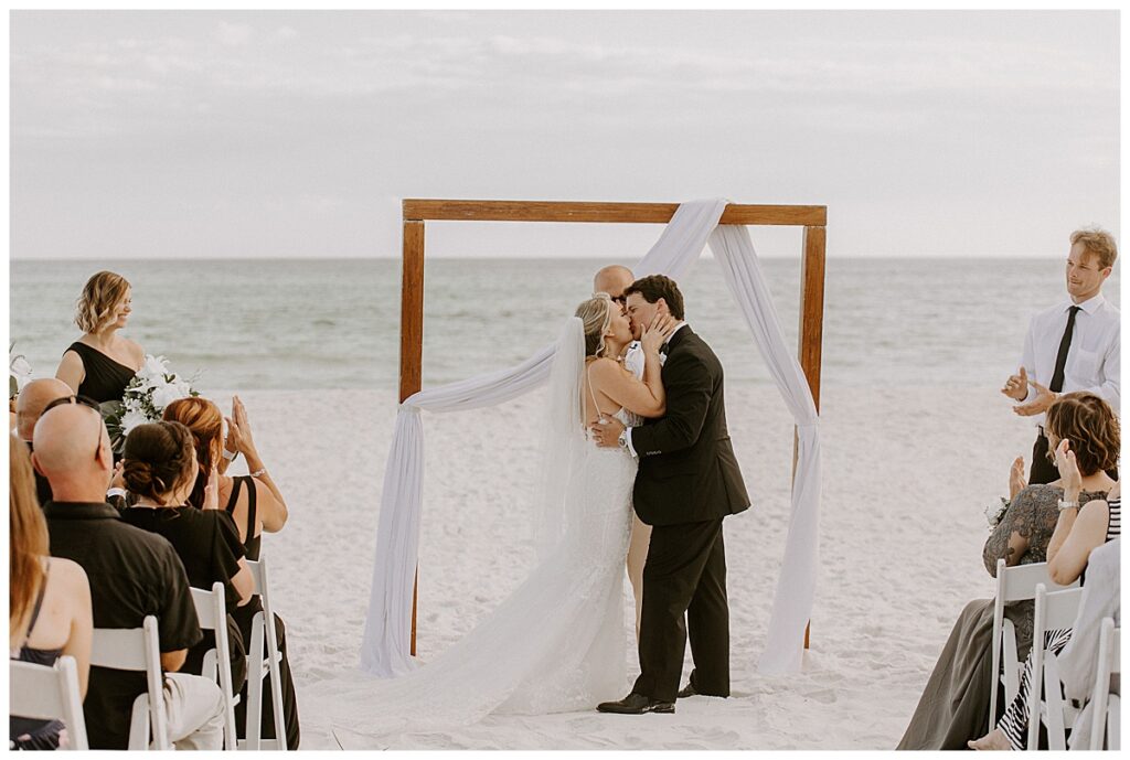 bride and groom kiss at altar
