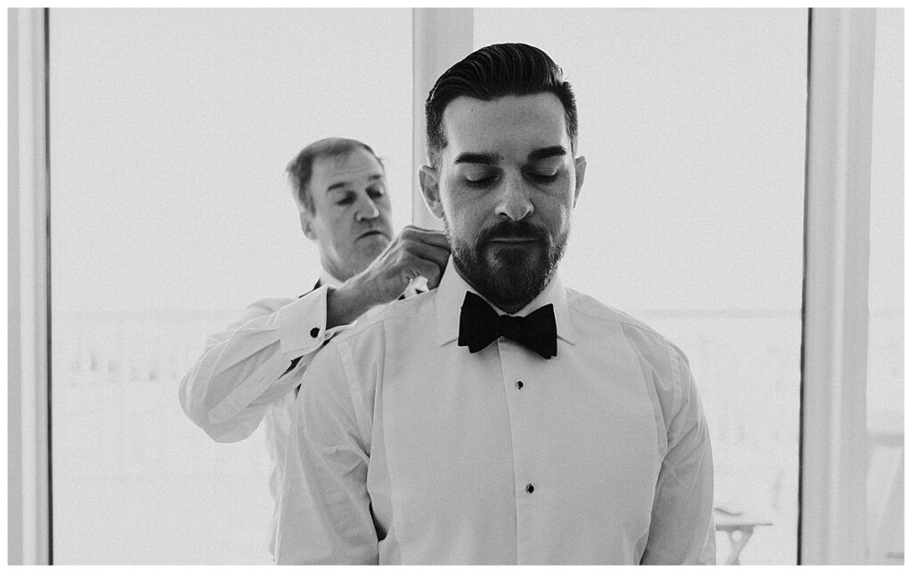 Grooms dad helping him get ready