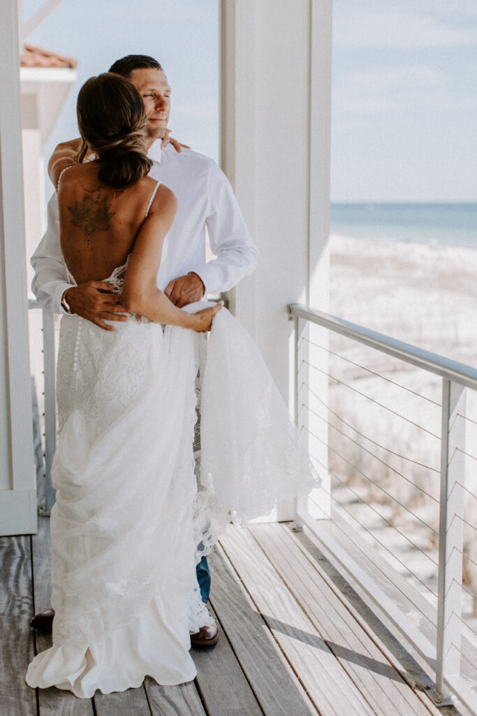 couple hugs on balcony of the beach house