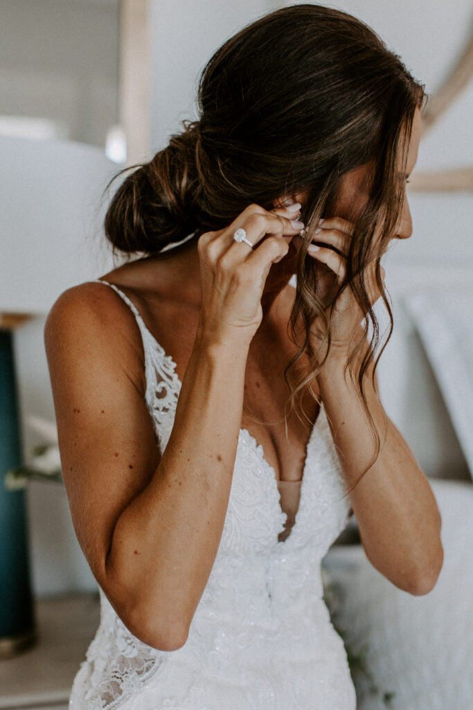 bride putting on earrings