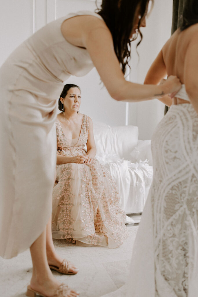 Mother of bride watching bride get dressed