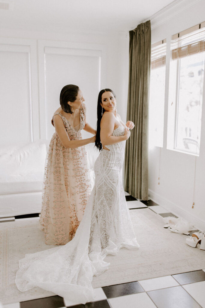 Mother of bride helping her get dressed