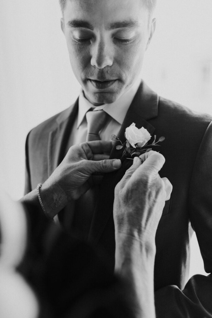 moms hands on boutonniere