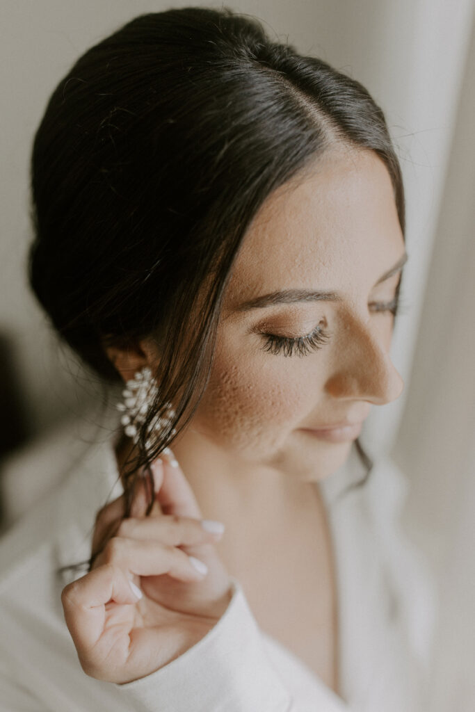 bride putting on earrings