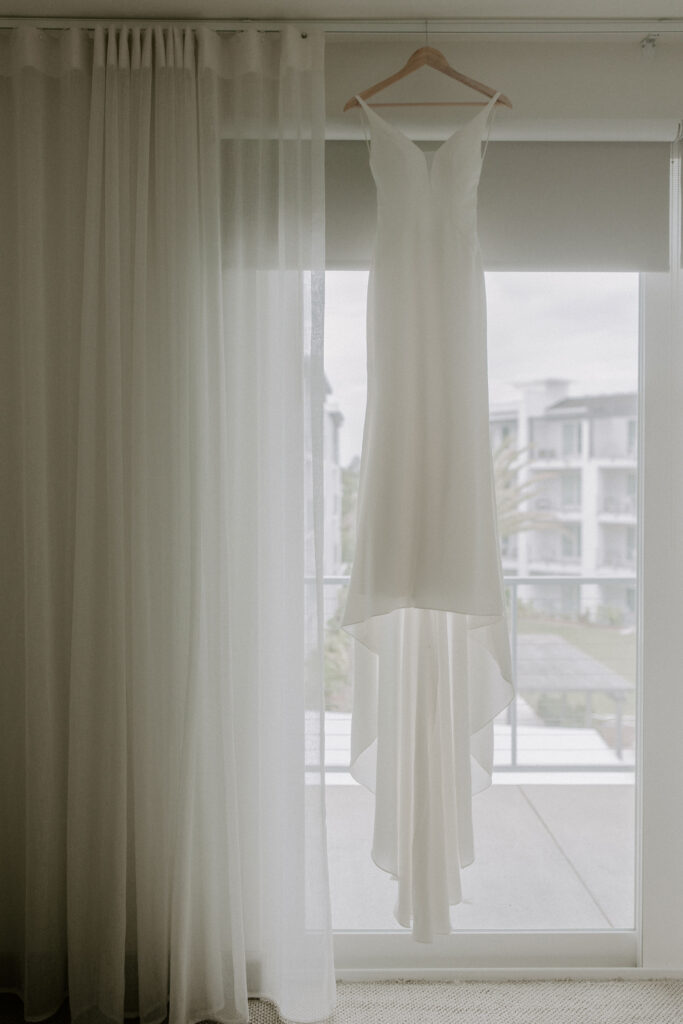 Wedding gown hanging in window