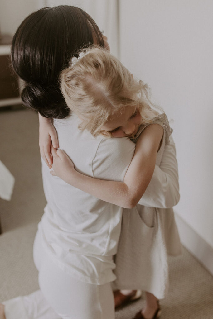 flower girl hugging bride