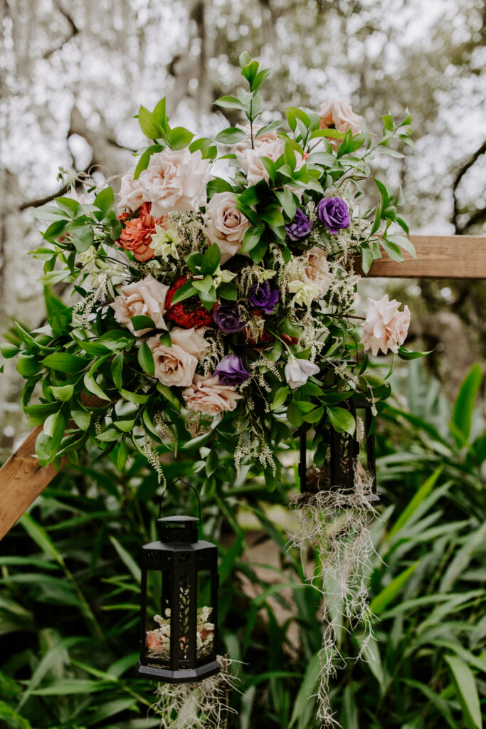 A closeup of the arbor at the Mill Pond Estate wedding venue, decorating with a floral arrangement and a black lantern.