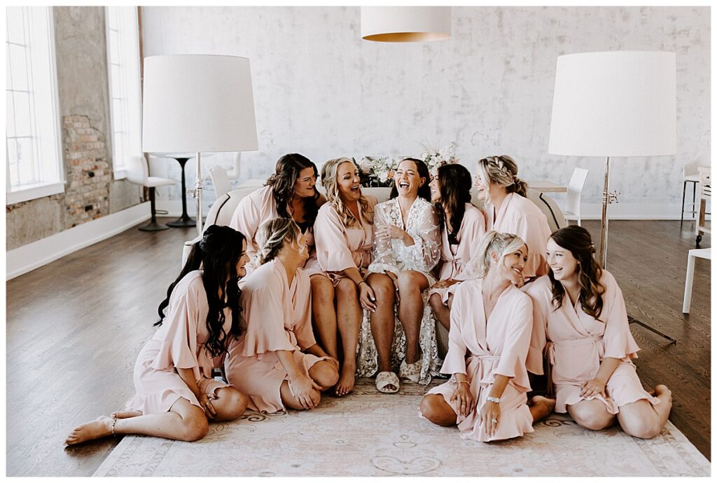 Bride and bridesmaids in matching robes sitting on a couch