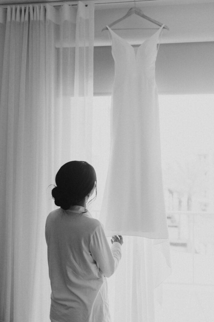 Bride looking at gown hanging