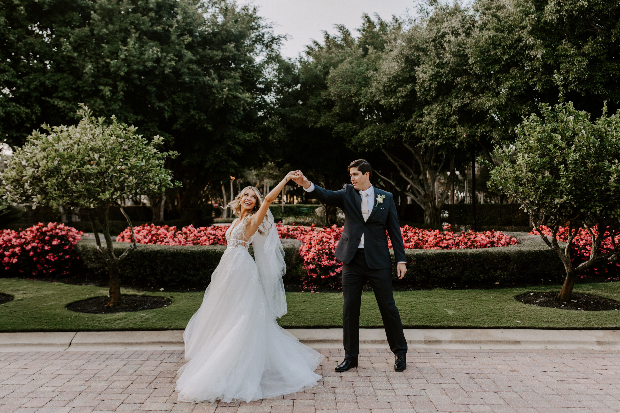 Bride and groom dancing in front of a rose bush