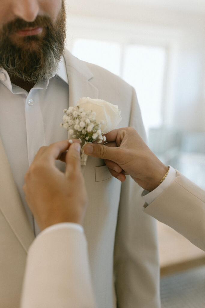 Son pinning on grooms boutonniere