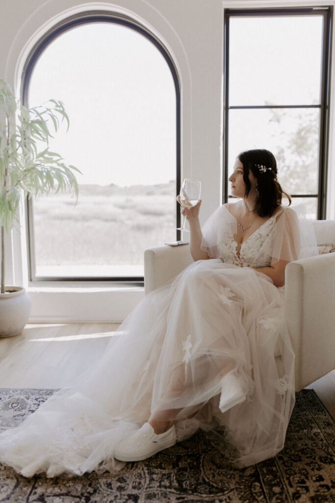 Bride sitting and holding a drink at her st augustine elopement