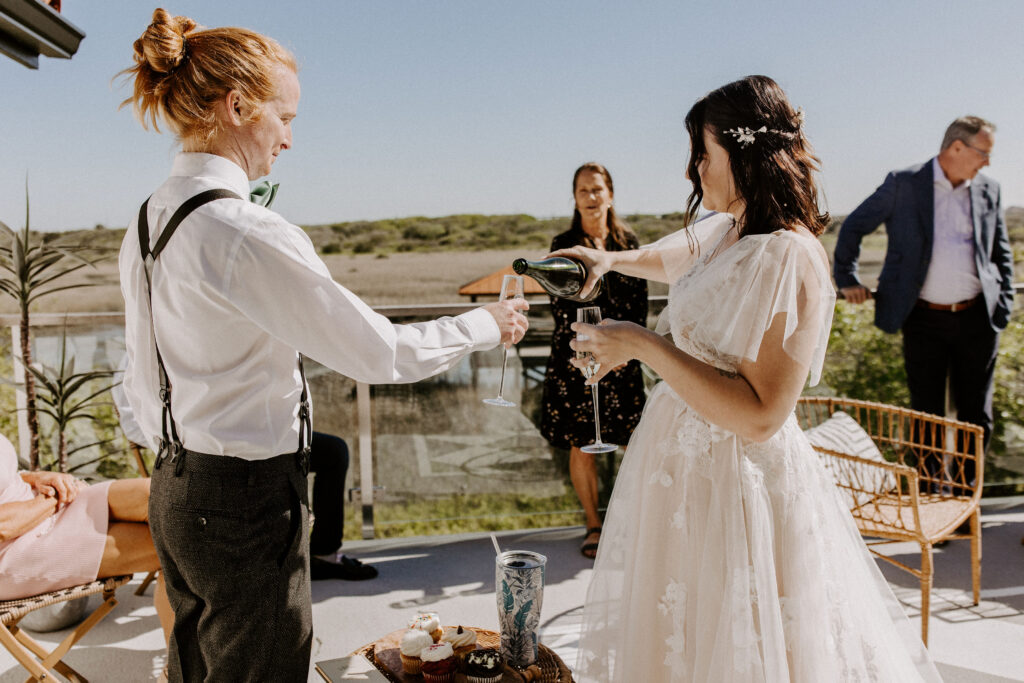 Couple pouring champagne at their wedding reception