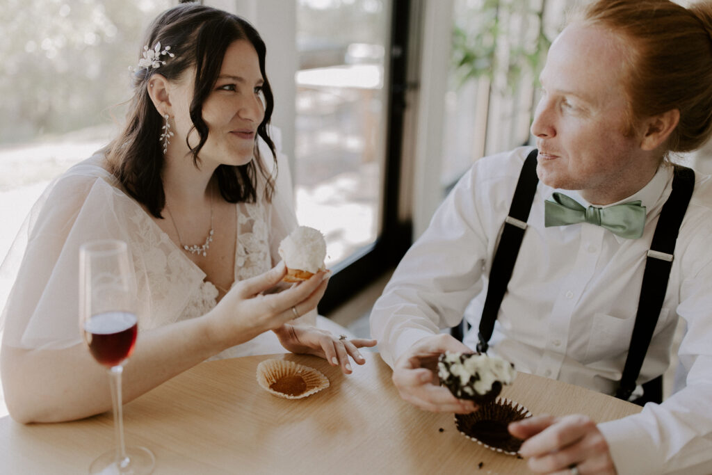 Couple eating cupcakes on their wedding day